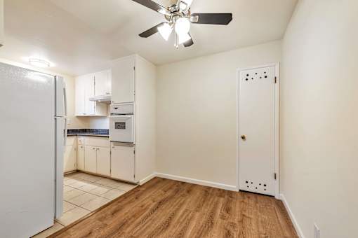 A kitchen with white cabinets and a white refrigerator.