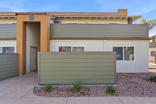 A modern house with a brown door and a green wall.