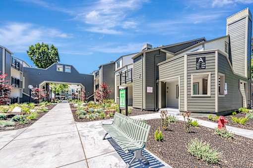 A modern building with a green bench in front of it.