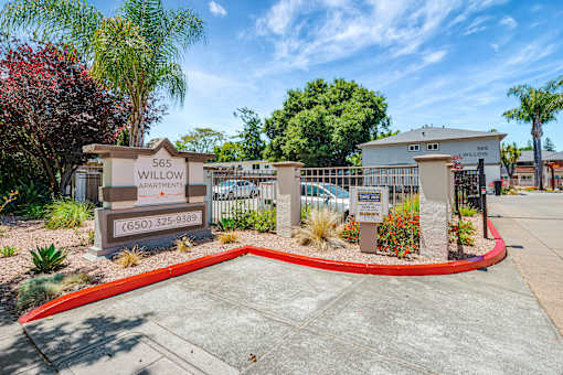 The image shows the entrance to the Willow Apartments with a sign and a red circular border.