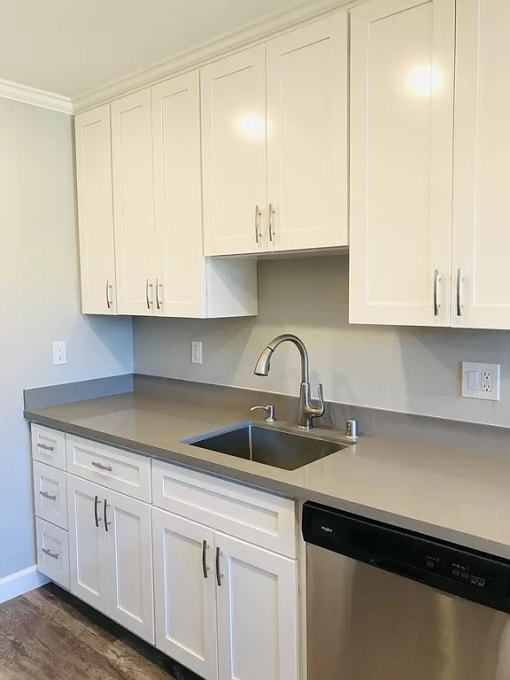 a kitchen with white cabinets and a sink