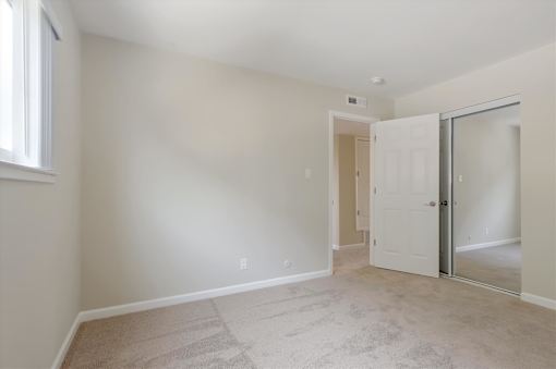 A room with a white door and carpeted floor.