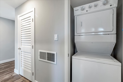 a white washer and dryer in a room with a door to a closet