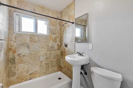 A bathroom with a sink, toilet, and tub.