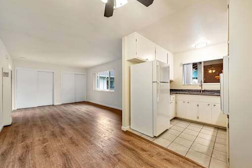 A kitchen with white cabinets and a refrigerator.