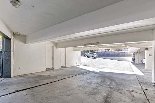 A car is parked in a white garage.
