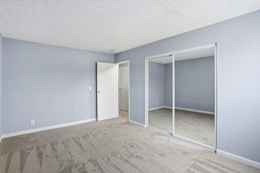 A room with a carpeted floor and a sliding glass door.