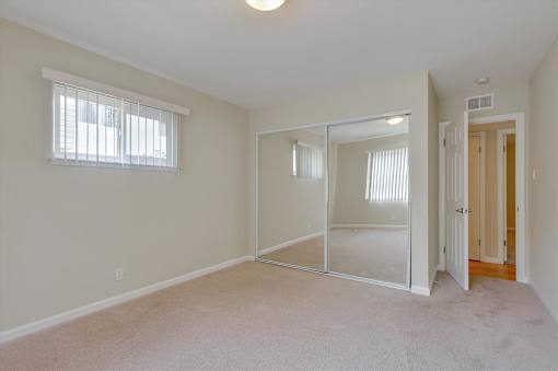 A room with a carpeted floor and a sliding glass door.