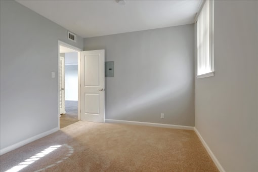 A room with a carpeted floor and a doorway leading to another room.
