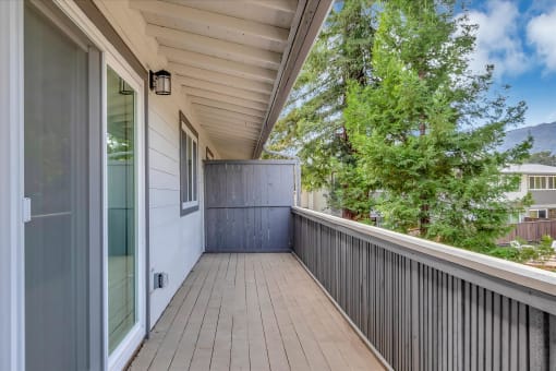 a long porch with a wood floor and a large glass door