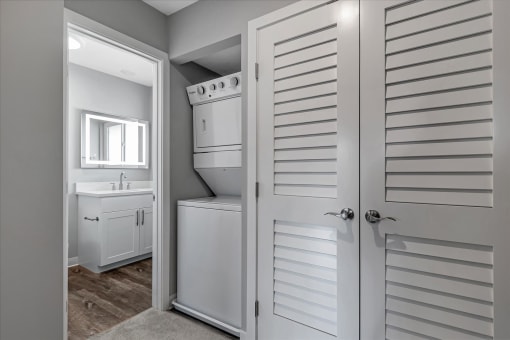 a white bathroom with a closet and a sink