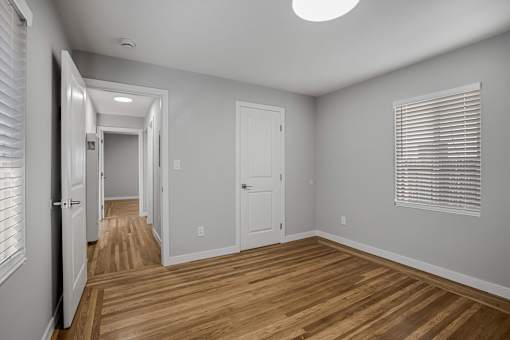 A long hallway with white walls and wooden floors.