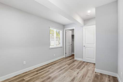 A room with a white door and a window with blinds.