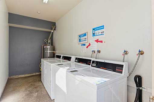 A laundry room with washers and dryers.