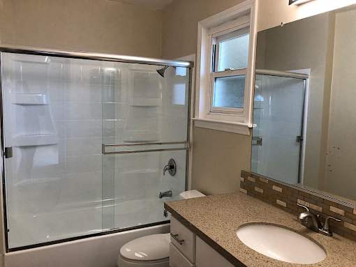 a bathroom with a shower and a sink and a toilet