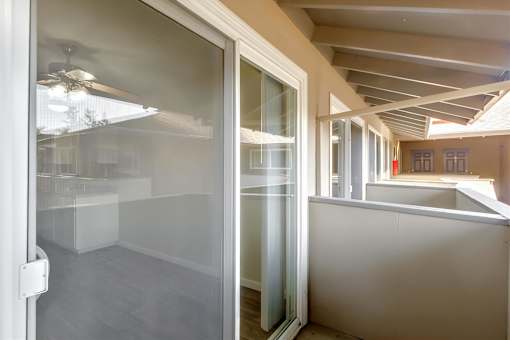 A room with a glass door and a ceiling fan.