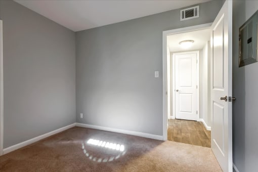 A room with a carpeted floor and a white door.