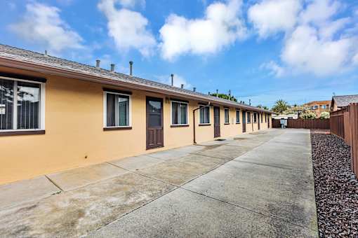 A row of houses with a sidewalk in front.