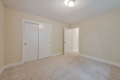 A room with two white doors and a carpeted floor.