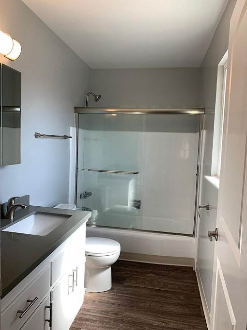 A bathroom with a toilet, sink, and shower.