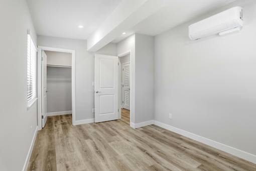 A room with a white door and a window with blinds.