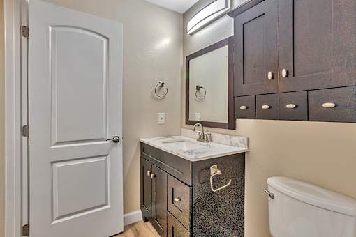 A bathroom with a white sink and a white toilet.