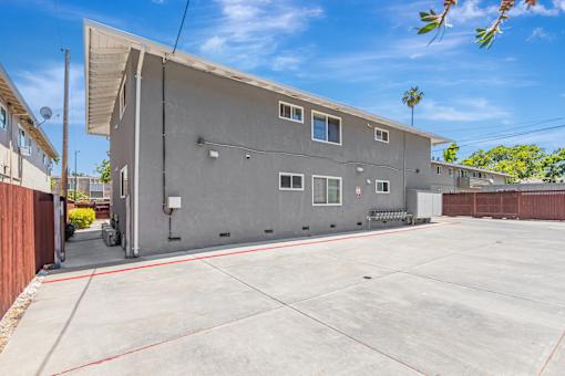 A grey building with a red line on the ground in front of it.