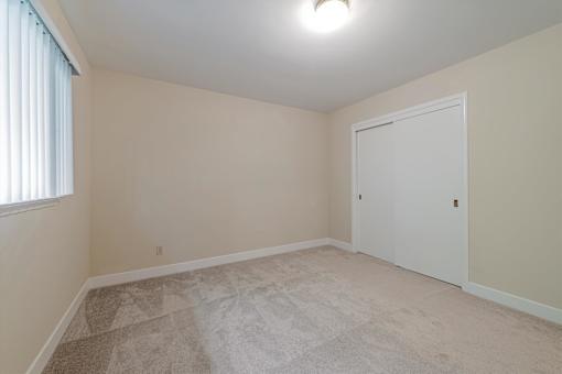 A room with a carpeted floor and a white door.