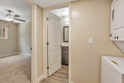 A white door is open to a kitchen area.