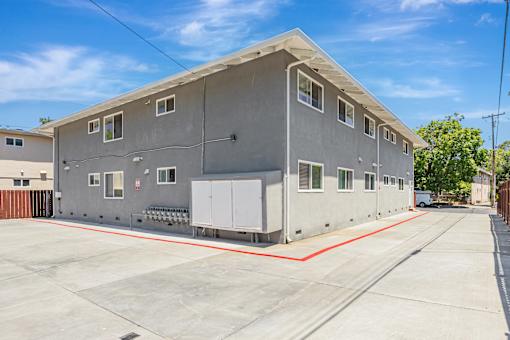 A grey building with a red line on the ground in front of it.