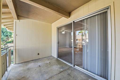A room with a sliding glass door and a concrete floor.