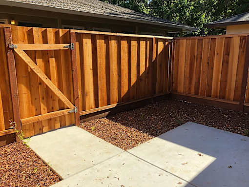 A wooden fence with a gate in the middle.