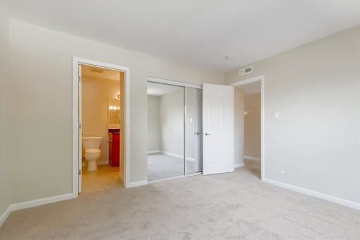 A room with a toilet and a trash can in the bathroom.