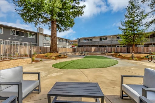 A paved courtyard area with landscaping and outdoor furniture