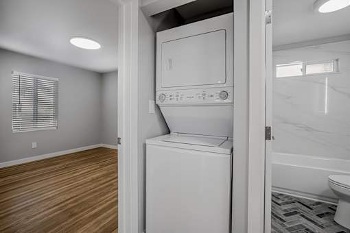 A white dishwasher is in a kitchen with wood flooring.