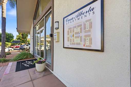 A sign for Casa Alberta Apartments is displayed on a building.