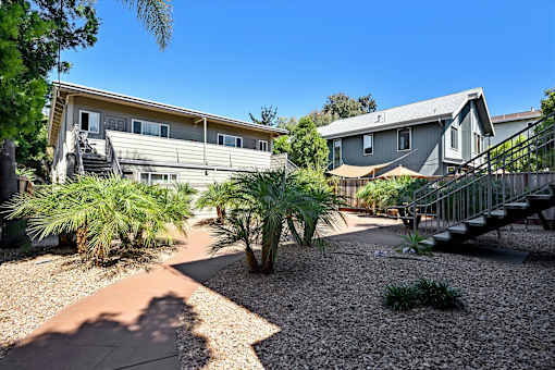 A sunny day in a residential area with houses and palm trees.