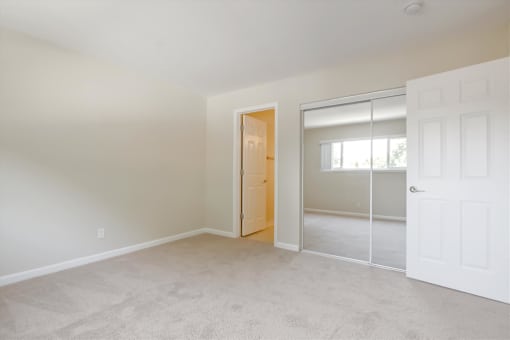 A room with a white door and a window with blinds.