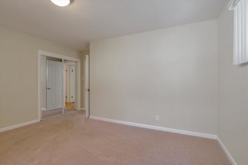 A room with a white door and a window.