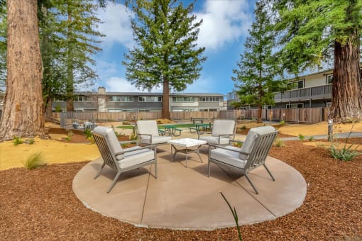 a patio with chairs and tables in front of a building