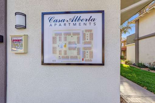 A framed picture of a floor plan for Casa Alberta Apartments is hanging on a wall.