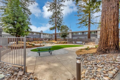 a community park with a picnic table and benches in front of a building