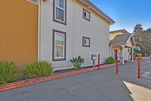 A building with a red brick border around a parking lot.
