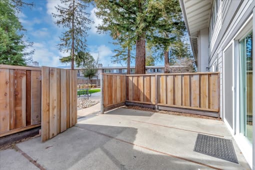 the private patio is enclosed by a wooden fence