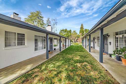 A long row of houses with green grass in between.