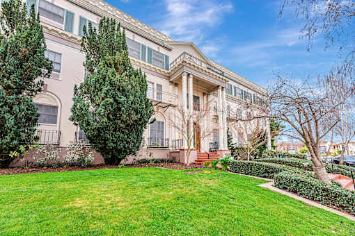A large, well-maintained lawn in front of a two-story building with a balcony.