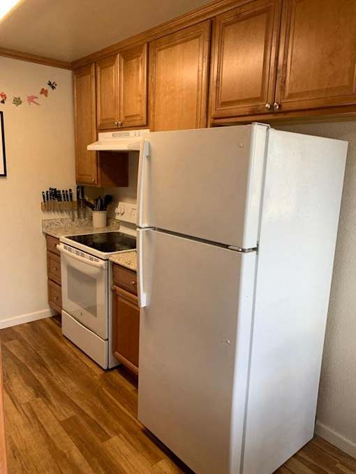a kitchen with a white refrigerator and a stove