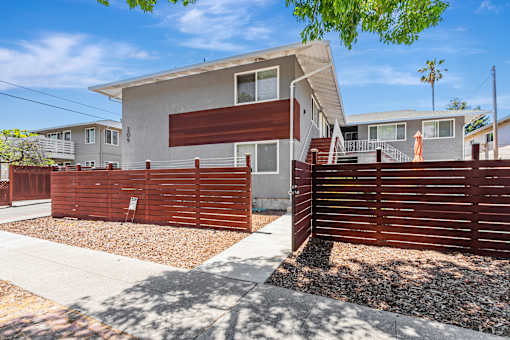 A modern house with a brown fence in front.