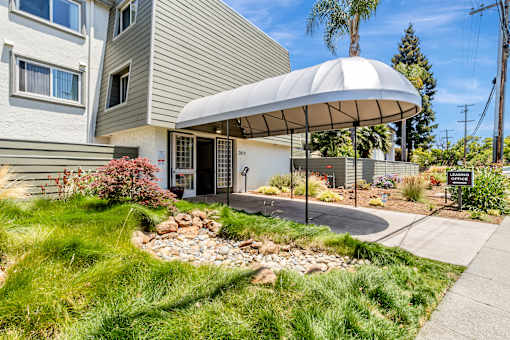 A modern house with a white umbrella-like structure in front.