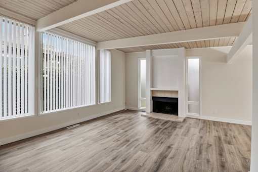 A room with a fireplace and wooden floors.